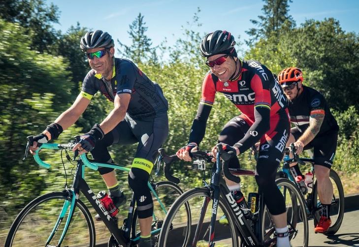 des cyclistes qui sourient en regardant lappareil photo