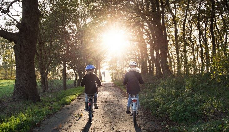 deux enfants se promenant a velo qui portent un casque de velo pour se proteger en cas de chute
