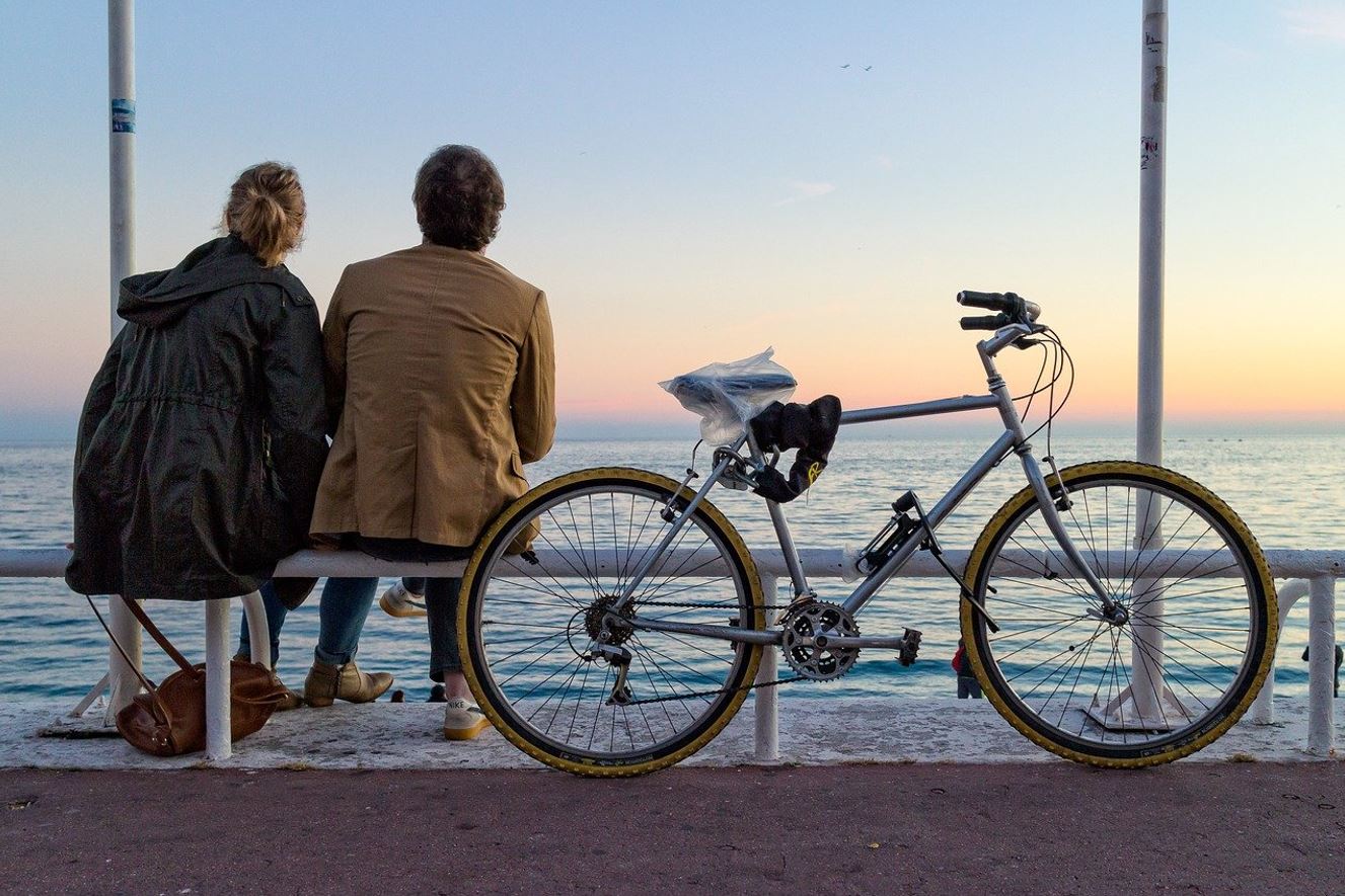 un couple assit sur un banc apres une belle balade a velo au bord de la mer a Nice