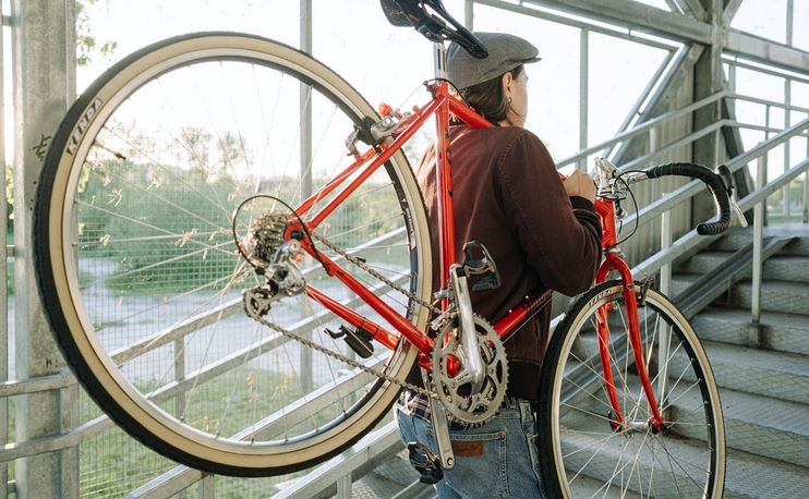 un homme qui porte son velo sur son epaule pour rentrer dans le metro