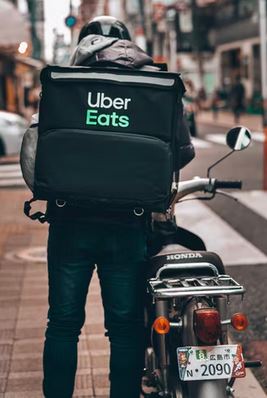 un livreur uber eats en scooter dans la rue
