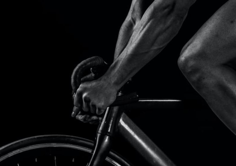 un homme sur son velo qui fait du spinning chez lui photo en noir et blanc