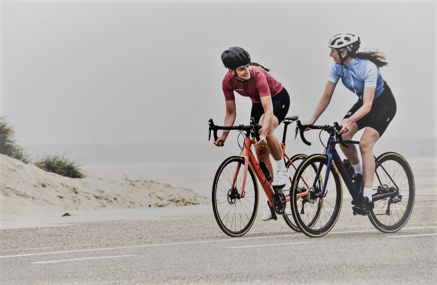 deux cyclistes feminins qui parlent en roulant sur leurs velos de route