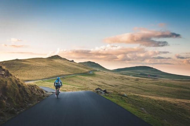 un cycliste en train de faire du velo sur une route de campagne splendide quelque part en Europe