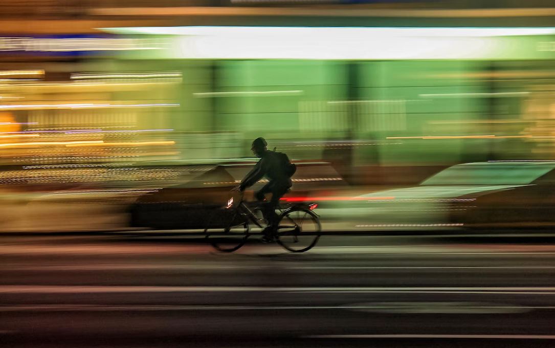 photo un cycliste urbain qui roule en plein nuit grace a ses eclairages avant et arriere