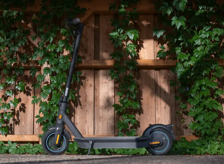 une trottinette electrique noire posee sur sa bequille